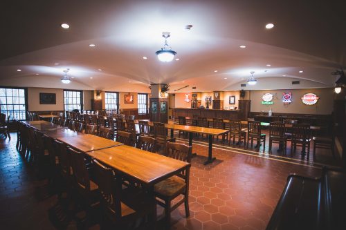 Rows of tables and chairs in front of a bar in the Schell's Brewery lower taproom